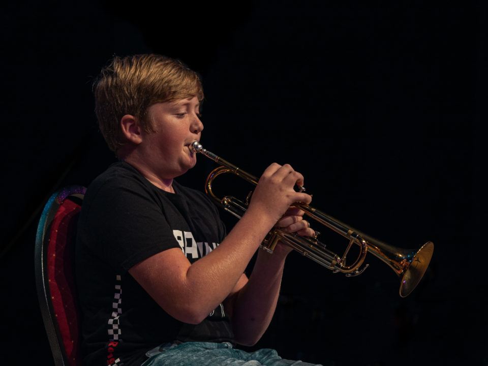 jongen speelt trompet tijdens examen